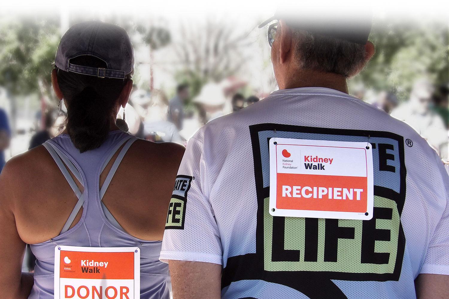 Two people at a Kidney Walk with Kidney Donor and Kidney Transplant signs