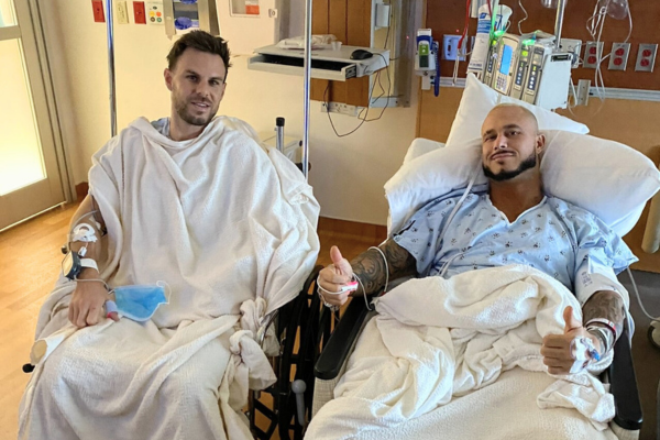 Jey and JJ sitting next to one another in hospital