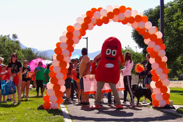 Sydney the Kidney under orange balloon arch