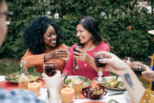 Two people toasting at dinner party.