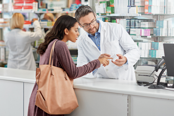 Patient speaking with pharmacist at store.