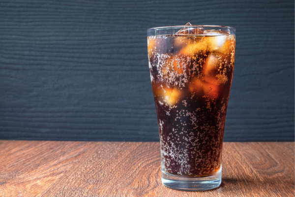 Glass of soda on wooden surface