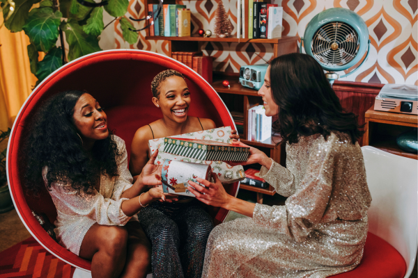 Three people happily exchanging gifts.