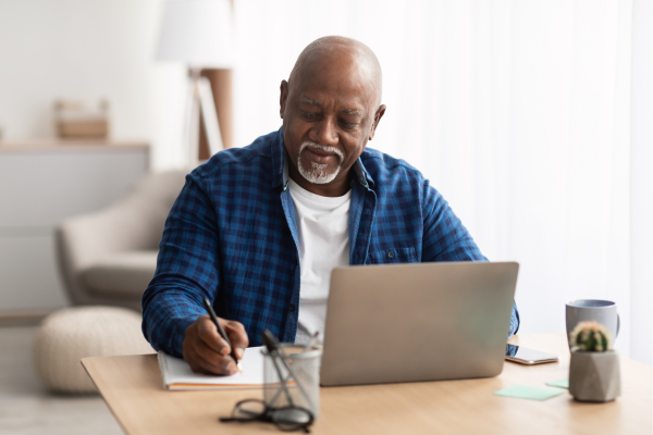 Older person happily taking notes from computer