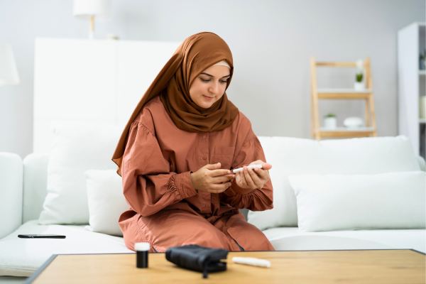 Person slightly smiling in living room checking blood sugar