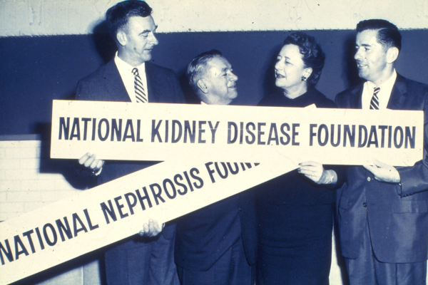 NKF Officers with signs depicting the change in name, and focus, of the Foundation, when The National Nephrosis Foundation became The National Kidney Disease Foundation.