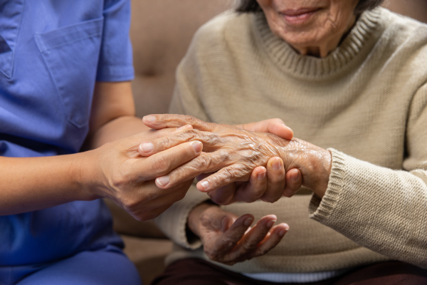 Older adult having their hand checked by doctor