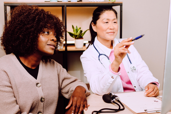 Doctor pointing at information with attentive patient nearby.