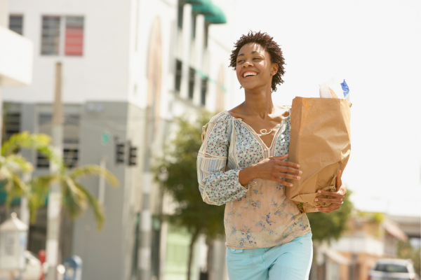 Delighted person walking with grocery bag