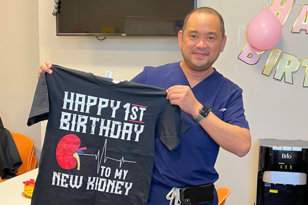 Patrick holding shirt "Happy Birthday 1st Birthday to My Kidney"