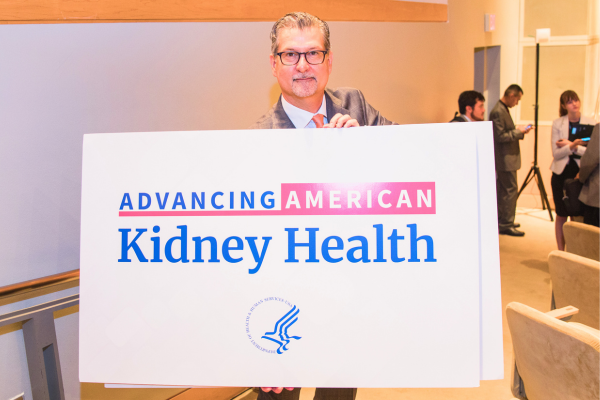 Kevin Longino holding Advancing American Kidney Health sign