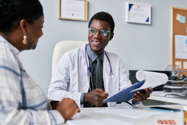 Smiling doctor speaking with happy patient