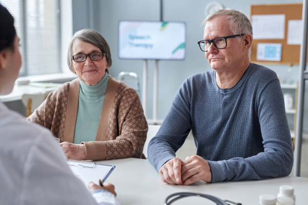 Two older adults speaking with a doctor