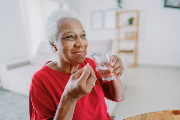 Happy older adult taking medicine