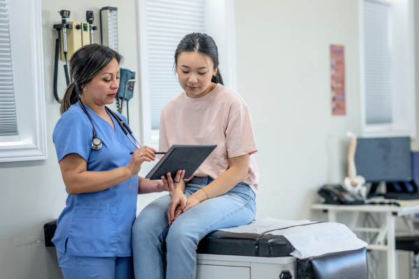 Doctor reading paperwork to young patient