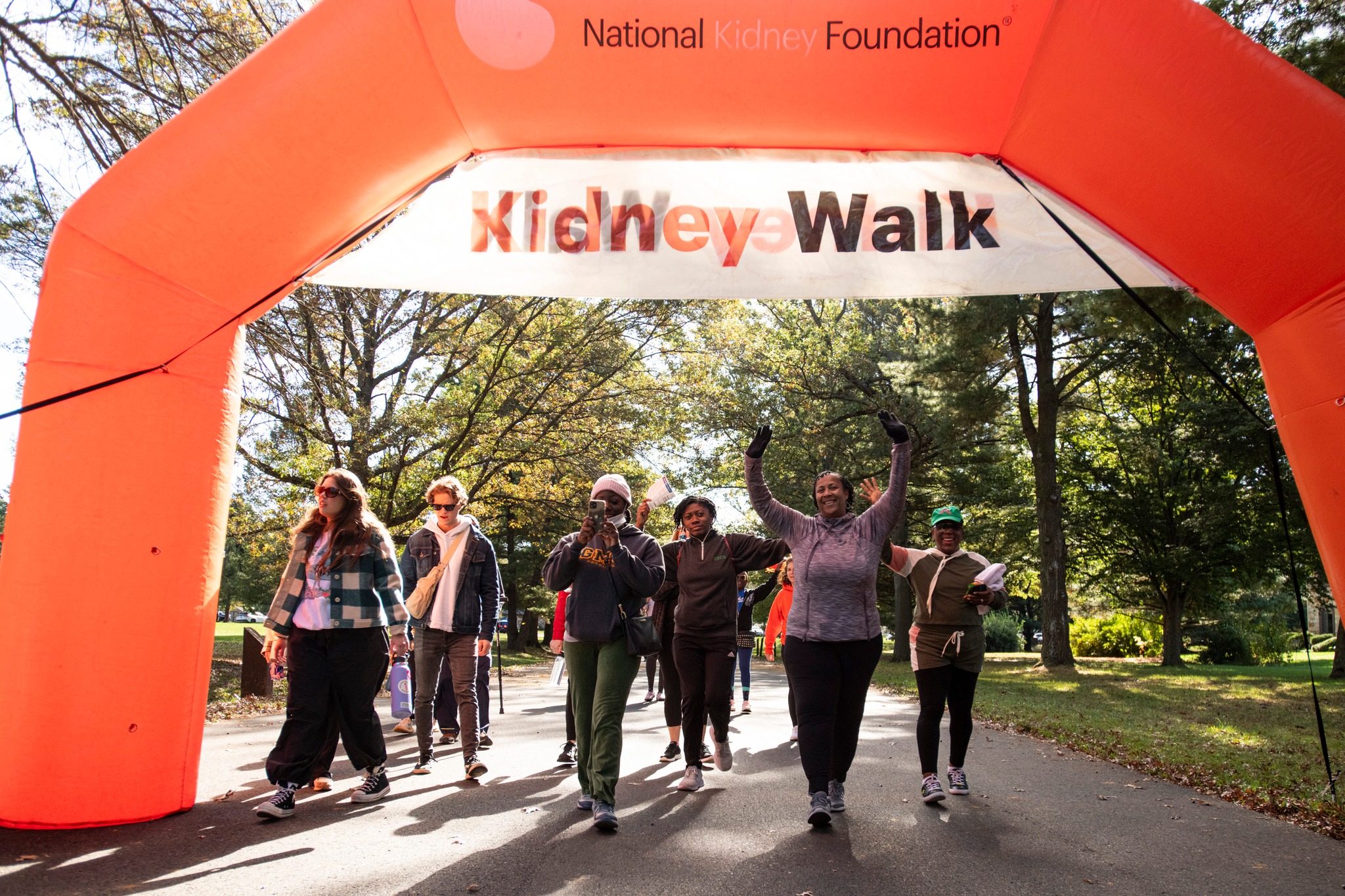 Kidney Walkers passing through an arch and cheering