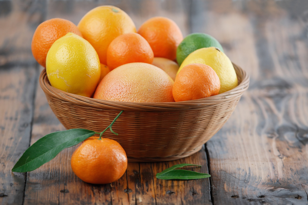 Basket of oranges, lemons, and other citrus fruits on a table