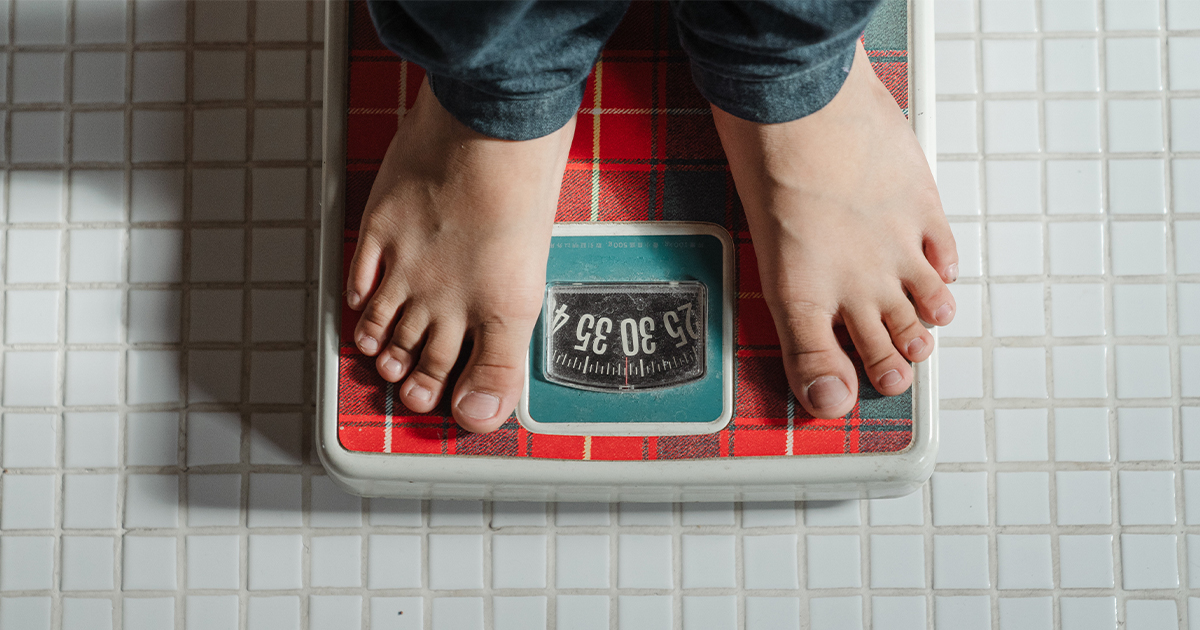 Top view of feet on weighing scale. Women weigh on a weight balance scale  after diet control. Healthy body weight. Weight and fat loss concept. Weight  measure machine. Body Mass Index or