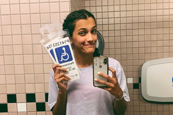 Shae holding handicapped parking pass