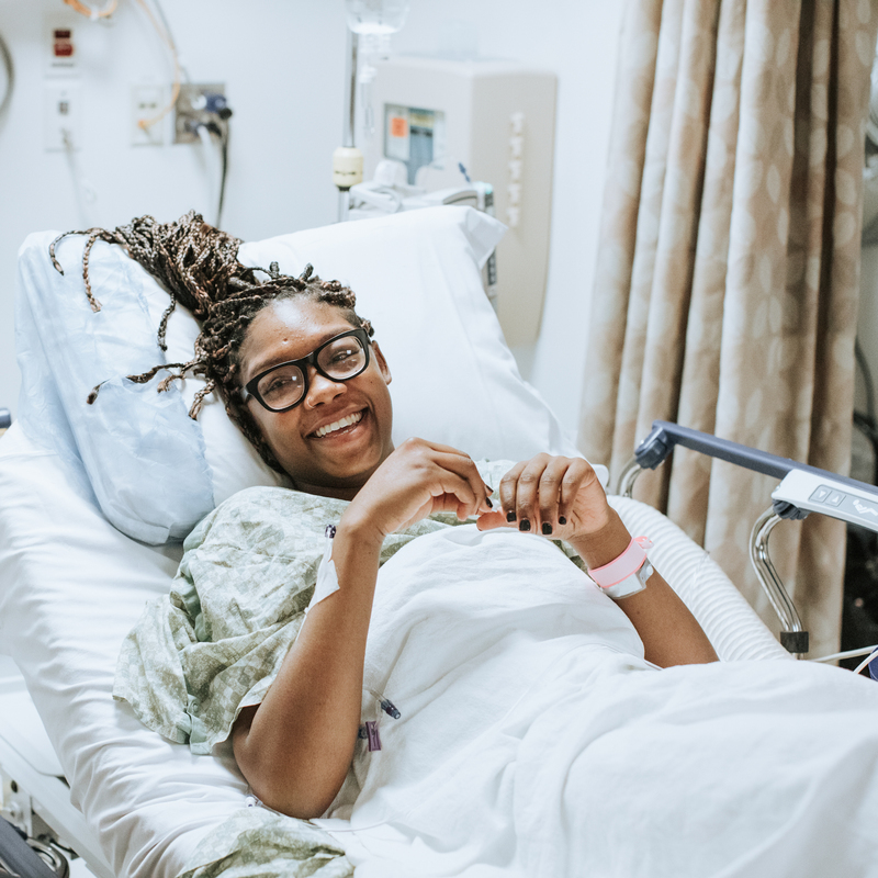 Woman smiling while laying in hospital bed