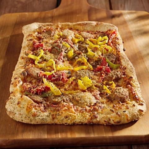 Homemade pizza with tomato sauce, cheese, onions, peppers, and ground beef topping