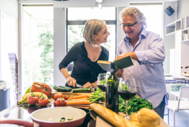 Couple smiling and cooking together