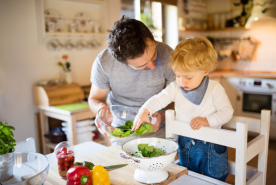 Parent happily cooking with child