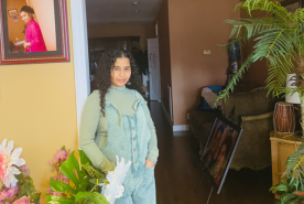 Dr. Saha standing by a picture of her relative