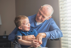 Older grandparent in wheelchair happily holding grandchild