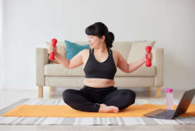 Seated person smiling while using small hand weights