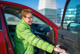 Older person getting into car