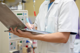 Doctor in dialysis clinic on laptop