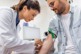 Doctor taking blood from patient