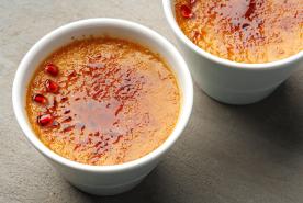 two creme brulees with pomegranate seeds on top