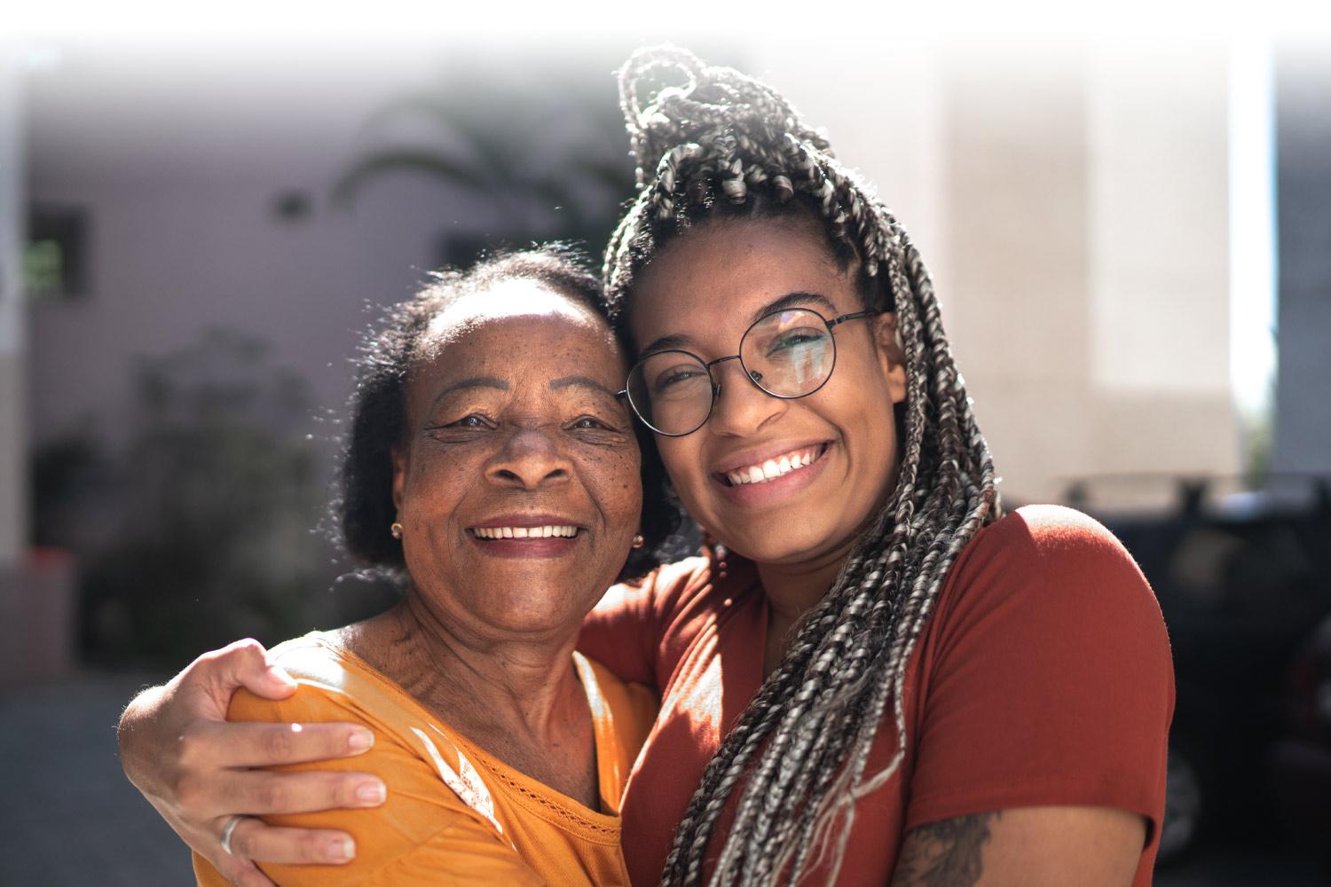 Grandmother and granddaughter hugging and smiling