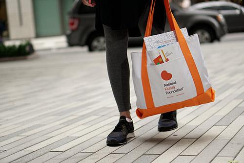 Person carrying an NKF totebag on the way to work