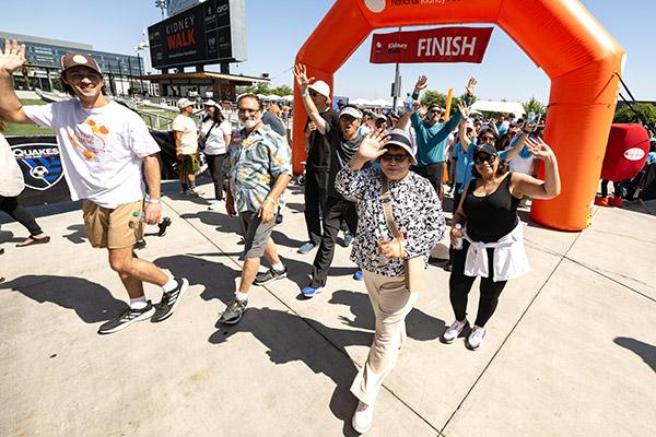 Group of walkers at a Kidney Walk event waving at the camera