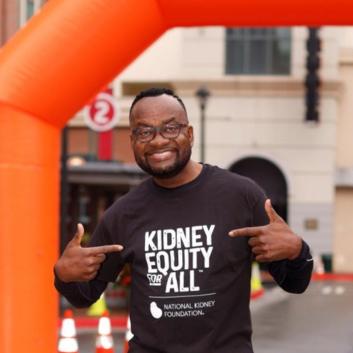 Anthony Tuggle posing at a Kidney Walk wearing his Kidney Equity for All t-shirt