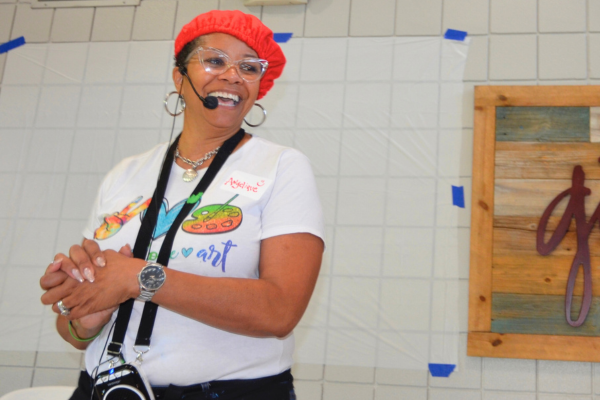 Angelique smiling and leading an art class