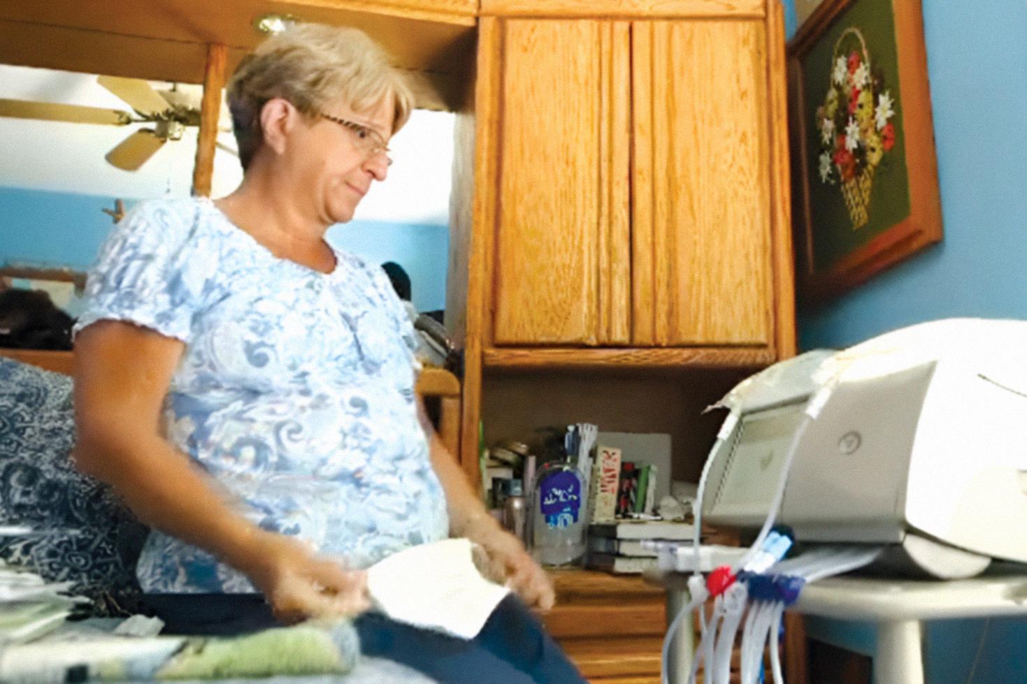 Woman setting up dialysis machine at home