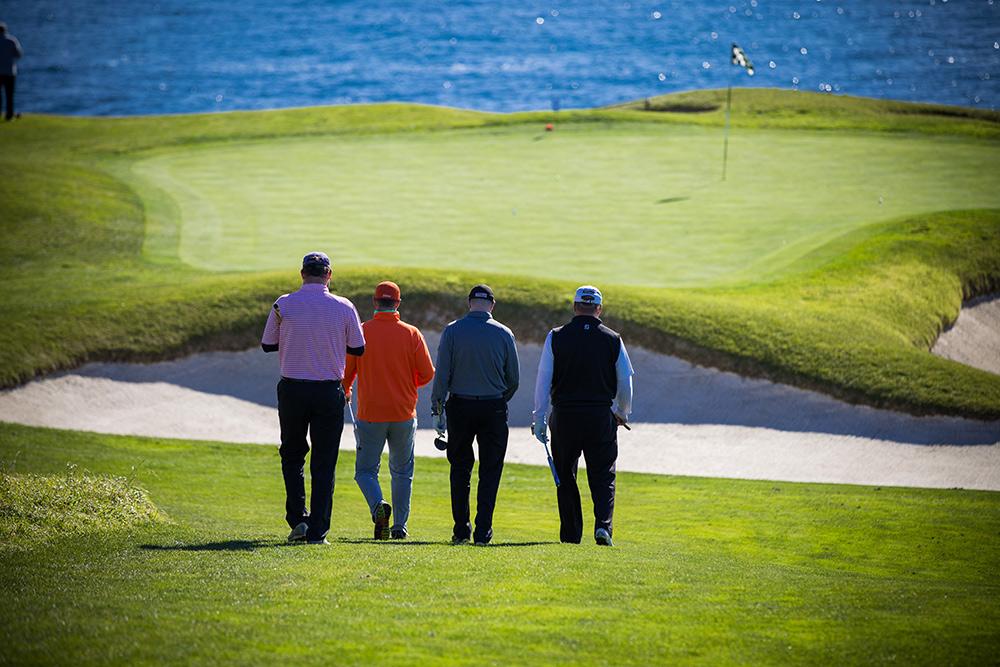 Four men walking on a golf course