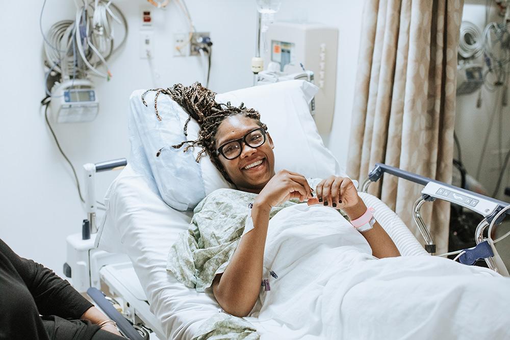 A woman smiling in a hospital bed