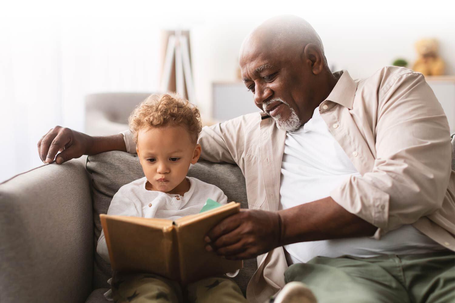 A man sitting and reading with a young boy