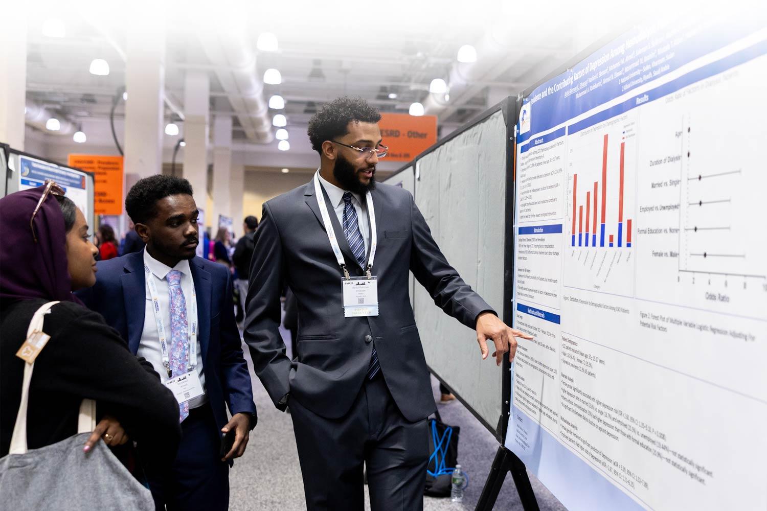 Two people looking at an abstract poster at SCM25
