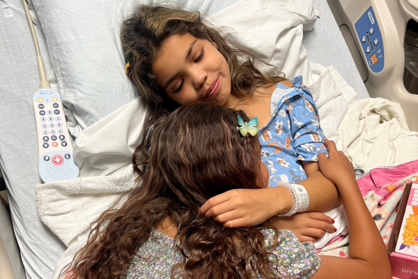 Reggie in hospital hugging sister