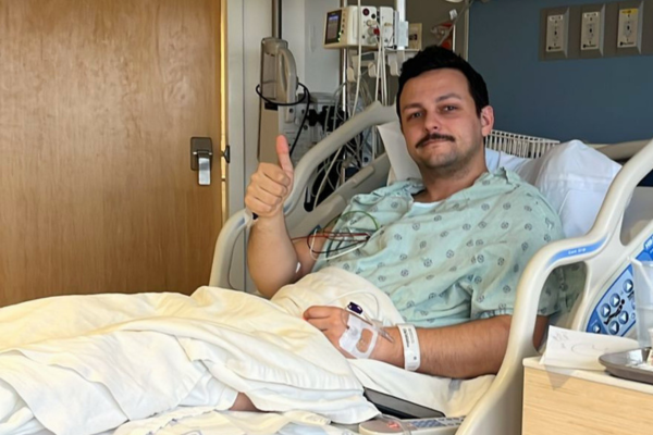 David in hospital bed giving thumbs up