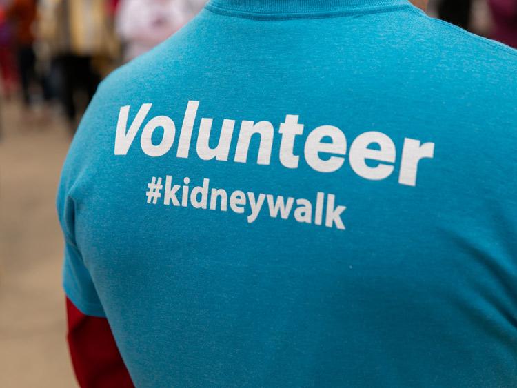 person wearing a t-shirt that says "volunteer #kidneywalk"