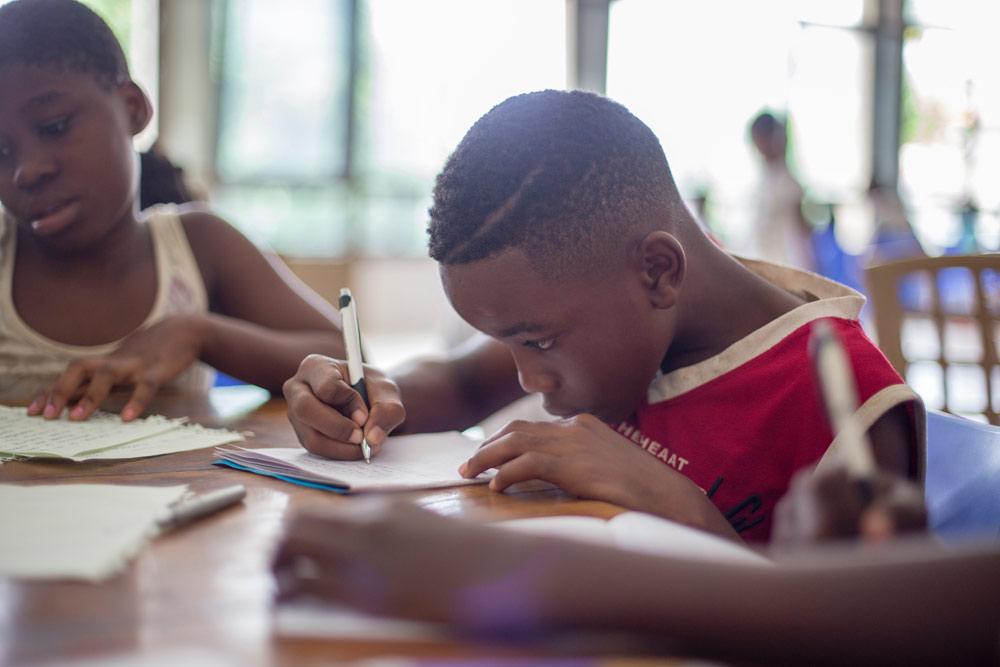 kid writing at table