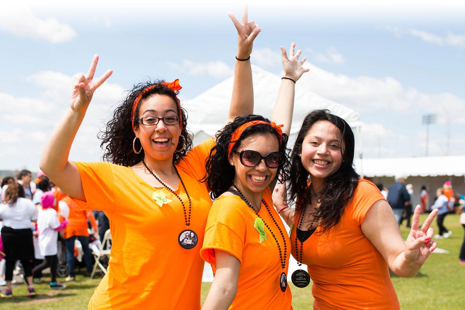 Three Kidney Walk participants cheering at a Walk event