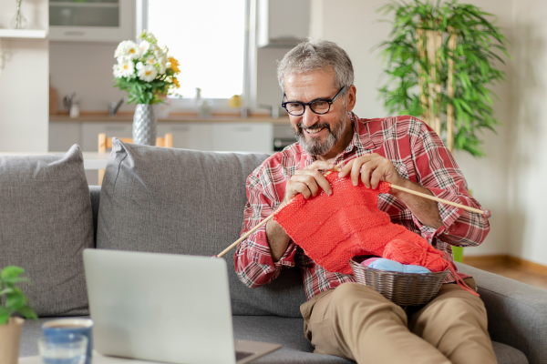 Person on couch learning how to knit via online video